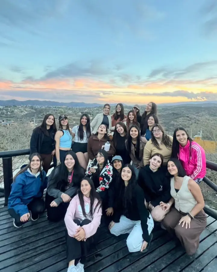 El grupo reunido en un deck de madera al atardecer.