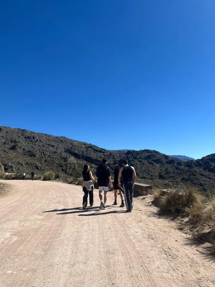 El grupo camina por un camino de tierra en las sierras.